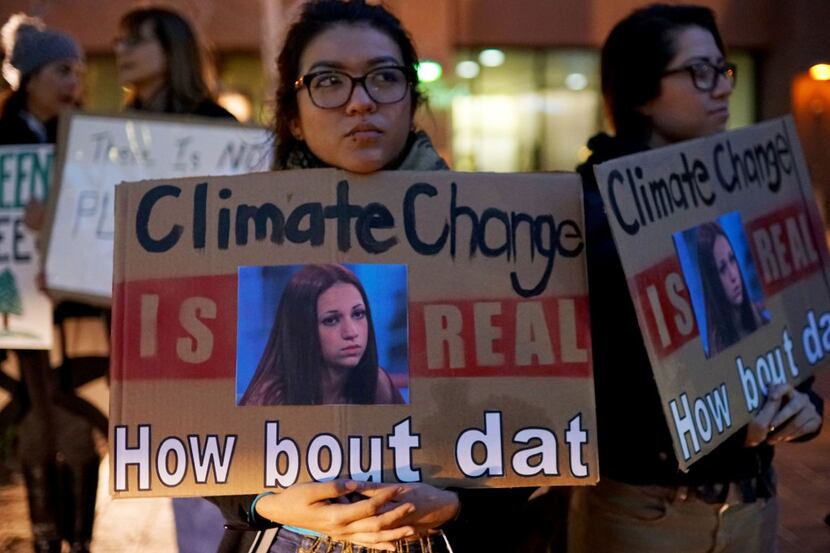 Protesters display signs in support of the environment during a rally against climate change...