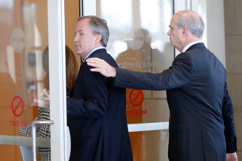 Texas Attorney General Ken Paxton (left) and his attorney Phillip Hilder enter the Collin...