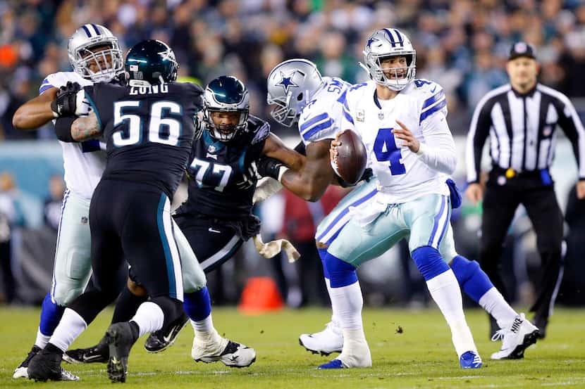 Dallas Cowboys quarterback Dak Prescott (4) looks for a receiver as he bounces around in the...