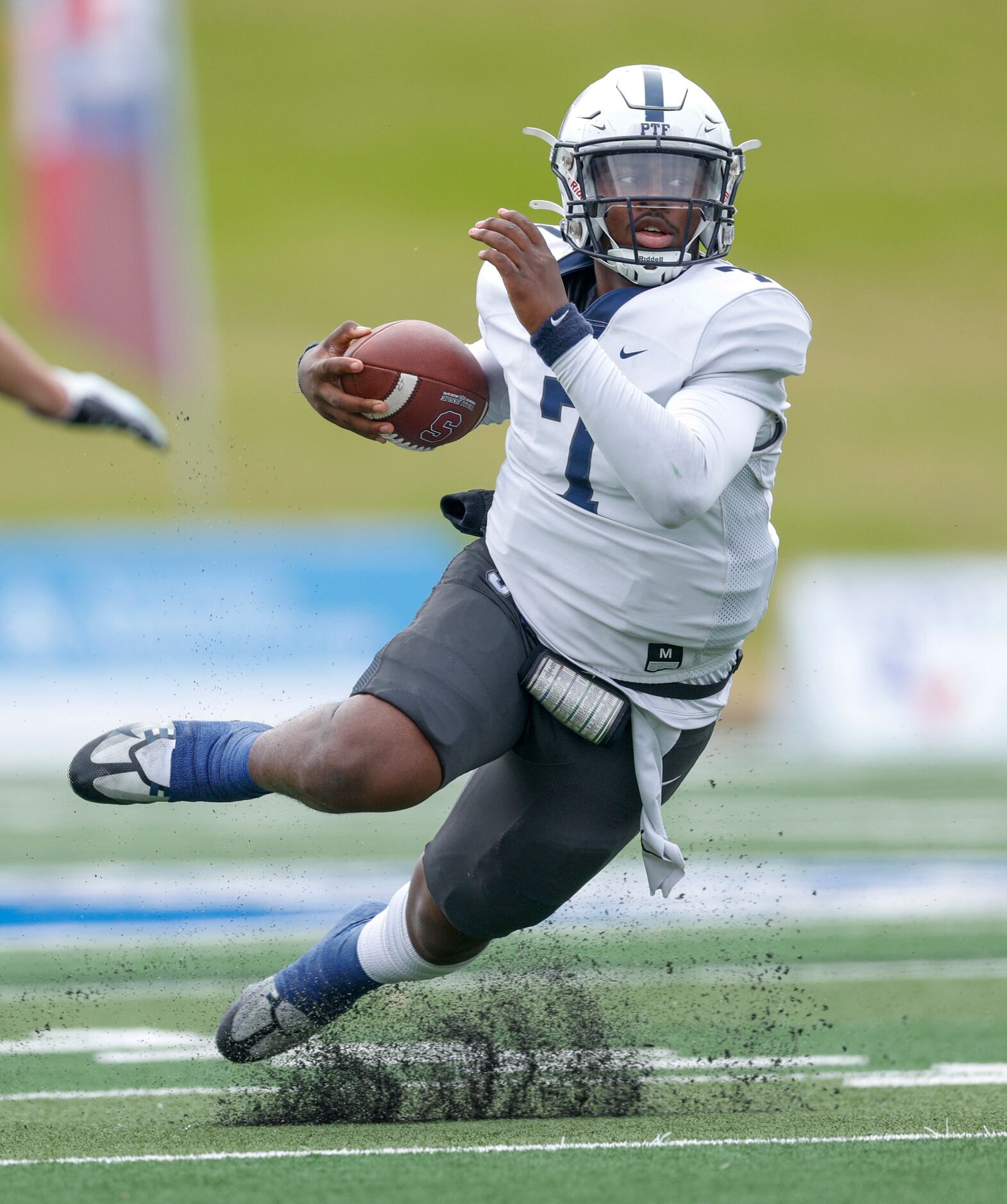 Fort Worth All Saints quarterback Jaylen Spriggs (12) slips as he runs the ball during the...