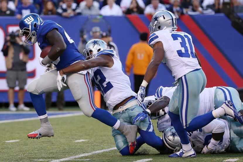 New York Giants running back Orleans Darkwa (26) rushes for a touchdown while being defended...