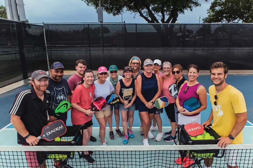 large group of pickleball players standing on a court