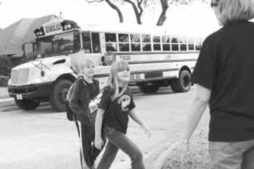  Nine-year-old twins Ben and Laura Schrader cross the street to meet their mom, Cyndy, after...