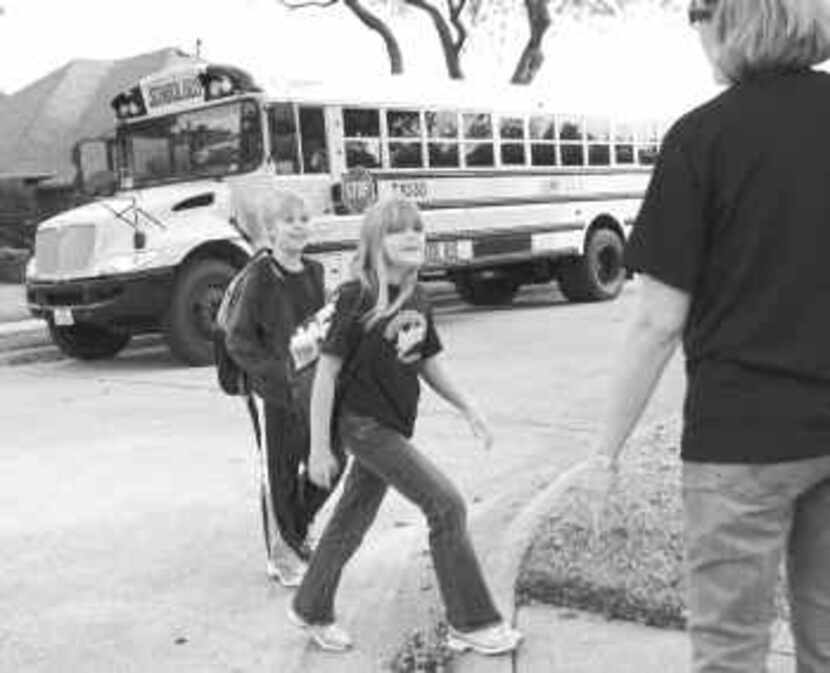  Nine-year-old twins Ben and Laura Schrader cross the street to meet their mom, Cyndy, after...