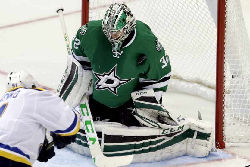 Dallas Stars goalie Kari Lehtonen, right,  blocks a shot against St. Louis Blues right wing...