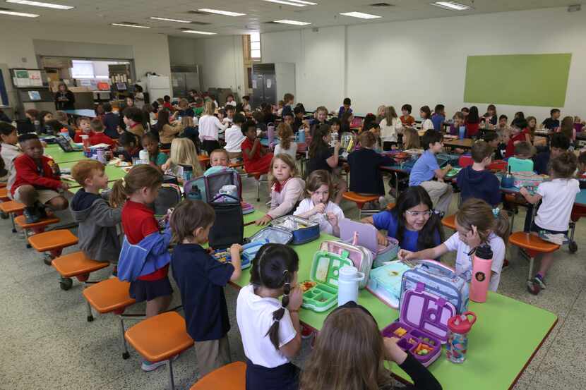 Children eat lunch Monday at Dallas ISD's Mockingbird Elementary School. The district offers...
