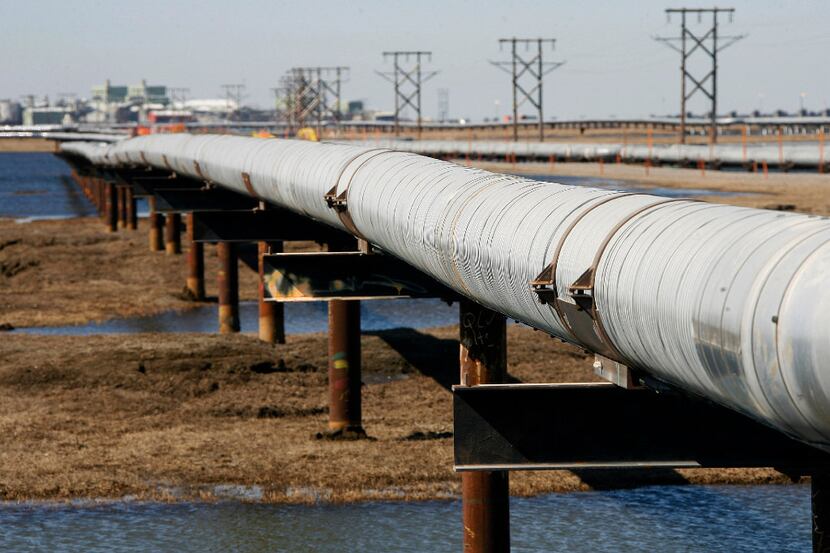 FILE - In this 2007 file photo, an oil transit pipeline runs across the tundra to flow...