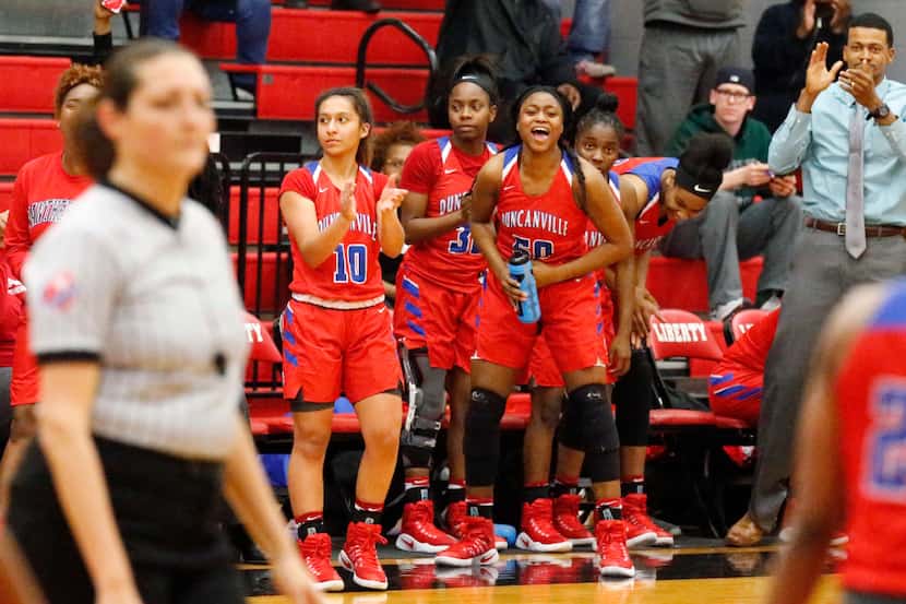 The Duncanville bench stands and cheers during the first half of play as Liberty High School...