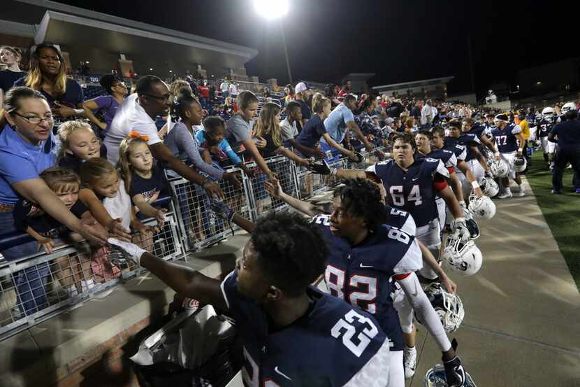 Allen High School fans and football players celebrate a win over Coppell High School at...