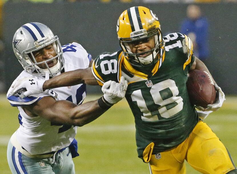 Green Bay Packers wide receiver Randall Cobb (18) tries to motor past  Dallas Cowboys strong...