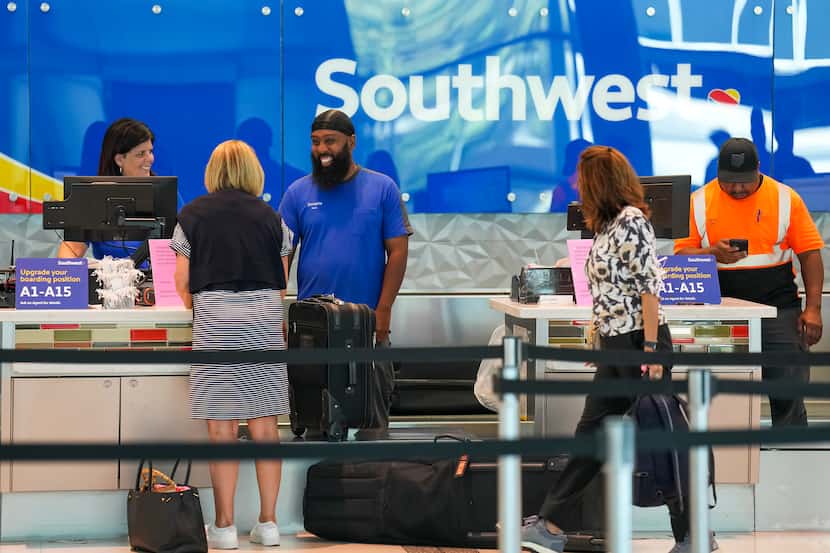 A Southwest Airlines ticketing an ramp agents work at a check in desk at Dallas Love Field...