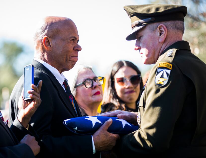 Gen. John M. Murray, commander of the U.S. Army Futures Command, presents an American flag...