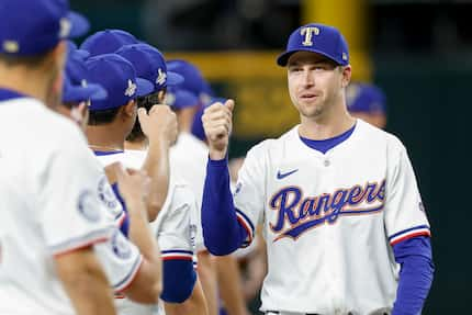 Texas Rangers starting pitcher Jacob deGrom greets teammates before the season opener at...