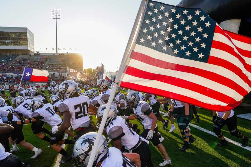 Denton Guyer wide receiver Josh Lumsden (88) carries the American flag as the teams take the...