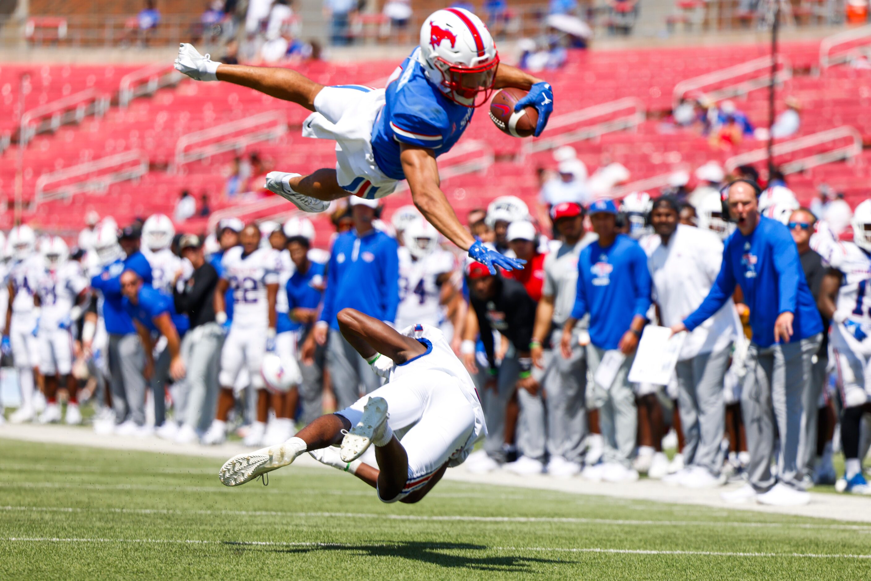 Southern Methodist wide receiver Jordan Kerley (top) dives over Louisiana Tech defensive...