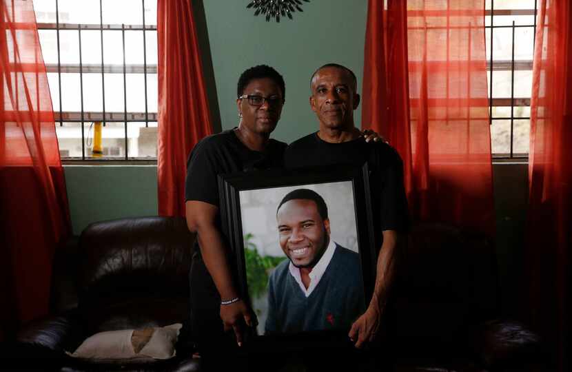 Allison and Bertrum Jean hold a photo of their son Botham Jean at their home in Castries,...