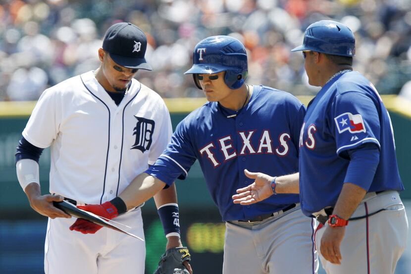 Texas Rangers' Shin Soo-Choo, center, takes his broken bat from Detroit Tigers' Victor...