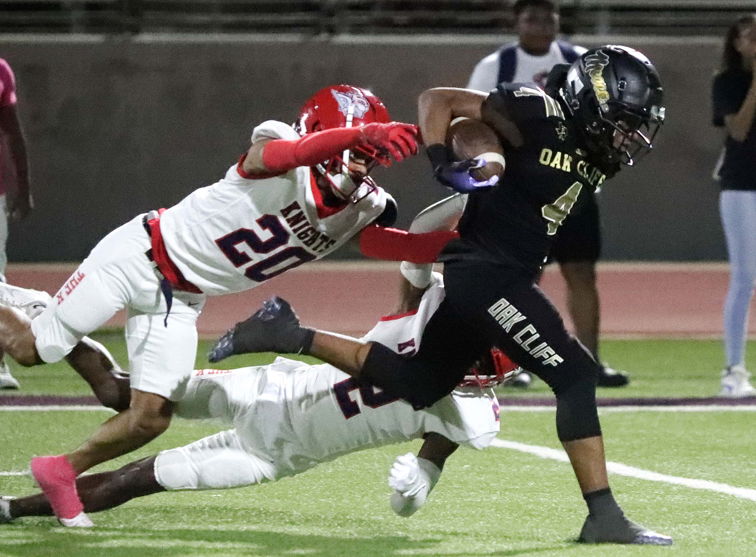 South Oak Cliff High School running back Khalil Ewell (4) is tripped up by Kimball High...
