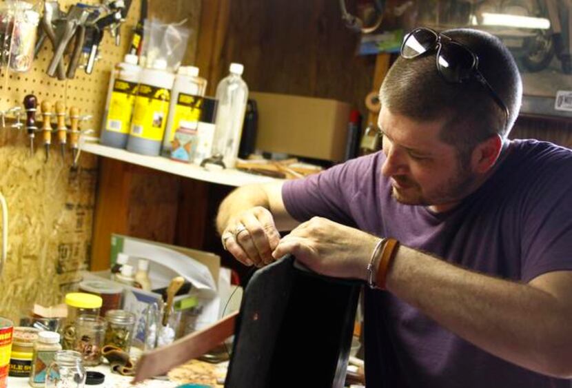 
Seth Cummings works on a carry-all at his leather-work company called Of Mud And Coal,...