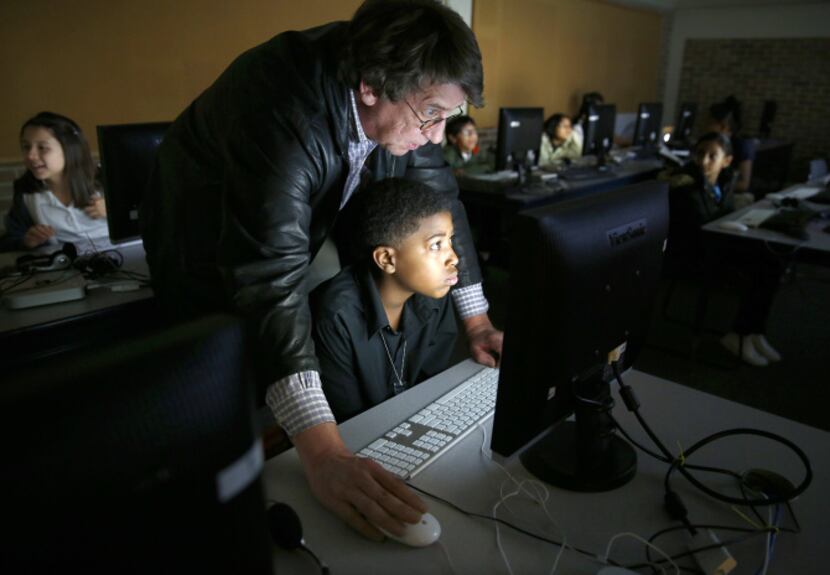 Fifth-grader Tyler Anderson receives help from Dean Baird in designing a web page at St....