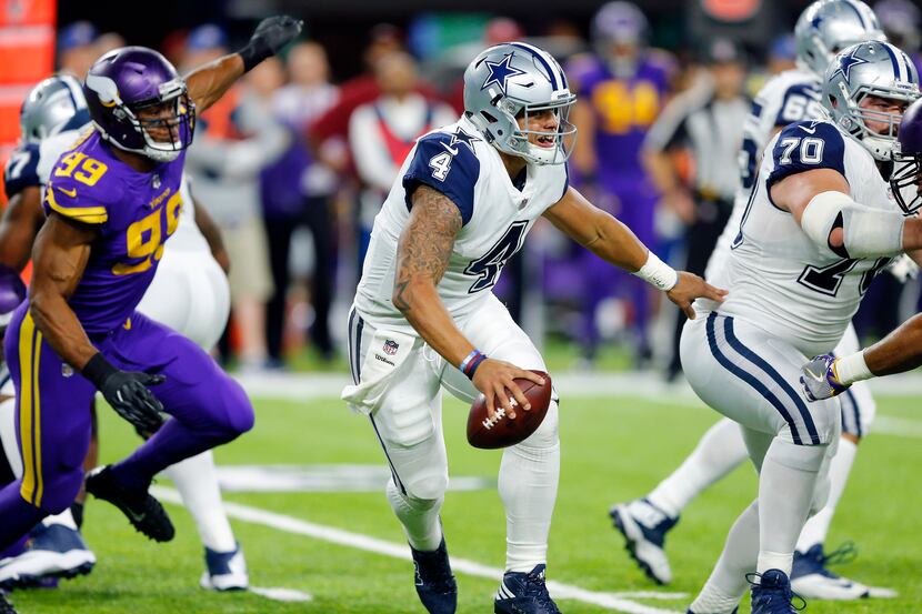 Dallas Cowboys quarterback Dak Prescott (4) is forced out of the pocket by the Minnesota...