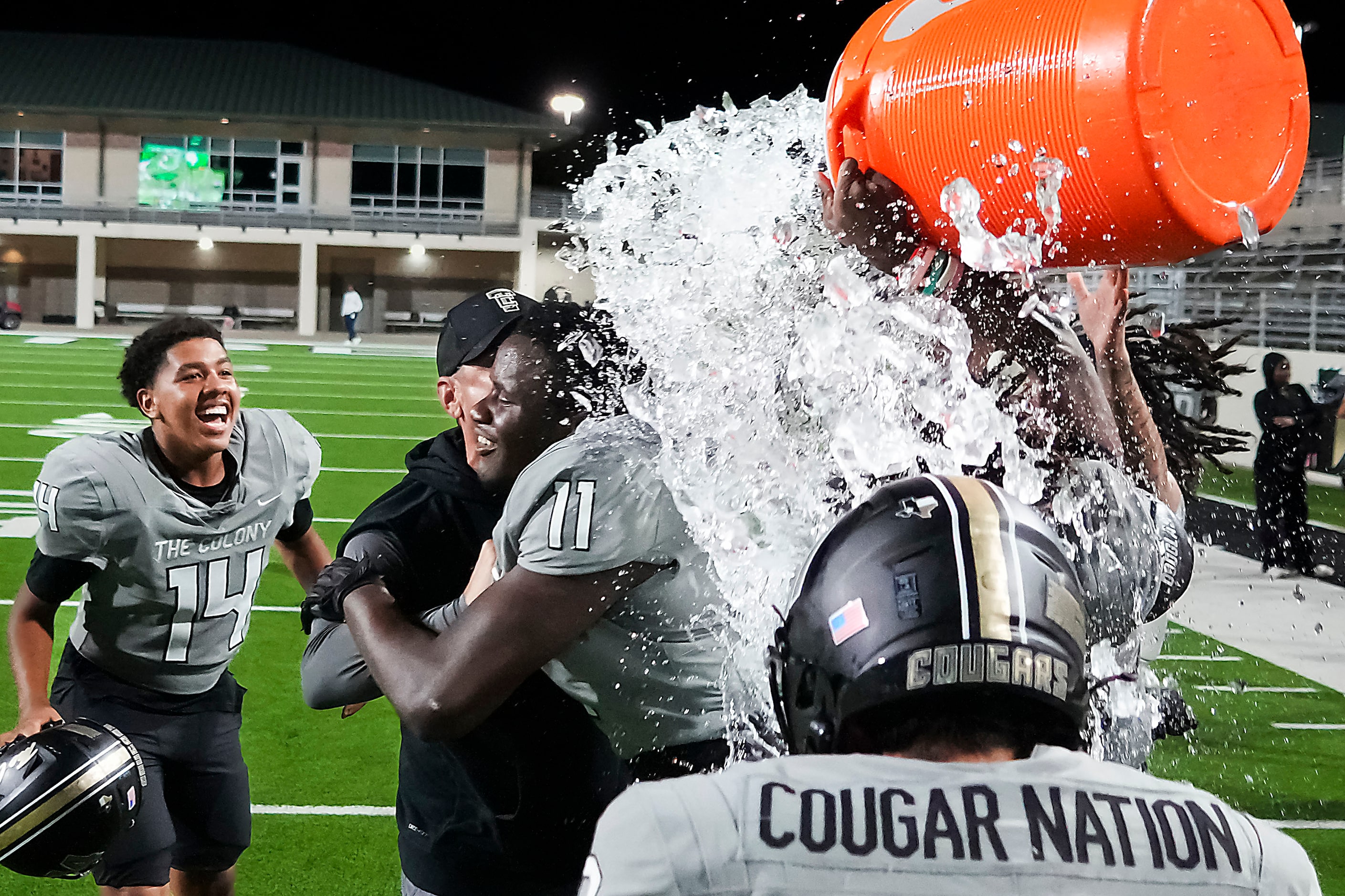 The Colony players douse head coach Rudy Rangel and defensive lineman William Adegbenro (11)...