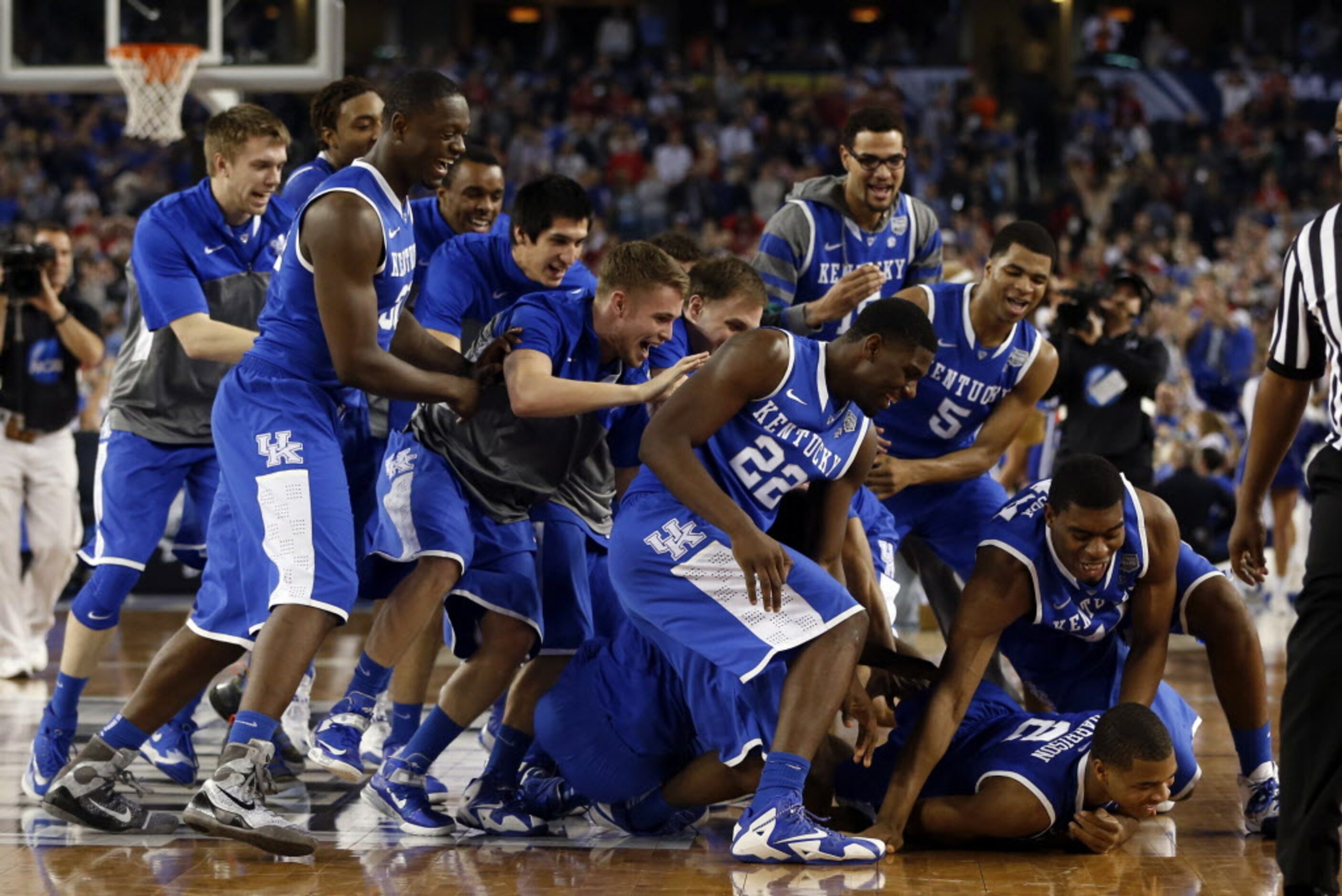 Kentucky Wildcats dog piles Kentucky Wildcats guard Aaron Harrison (2) after defeating the...