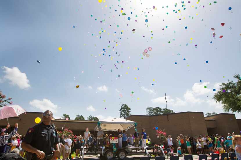 Balloons fly skyward during a community memorial celebrating the lives of the Stay family at...