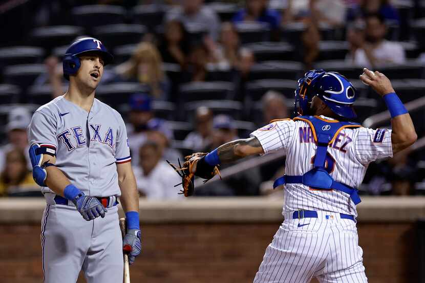 Texas Rangers' Nathaniel Lowe reacts after striking out as New York Mets catcher Omar...