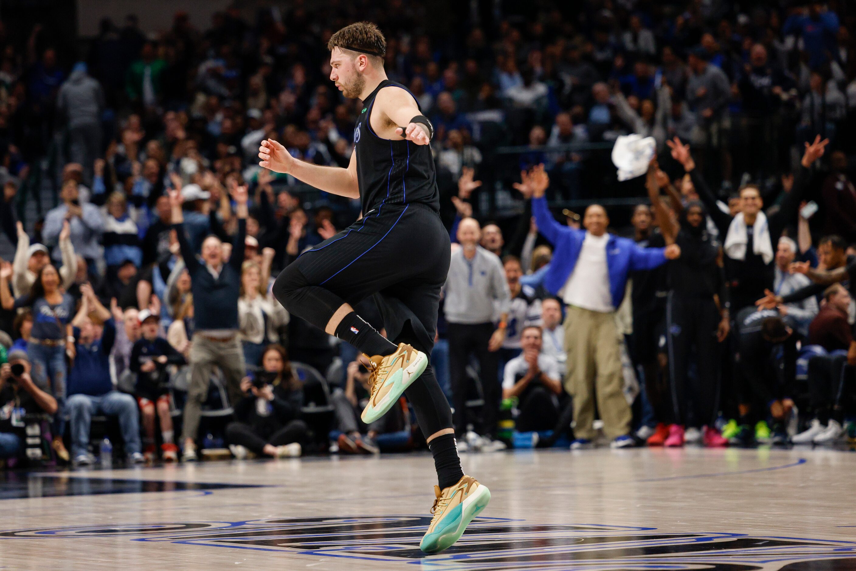 Dallas Mavericks guard Luka Doncic (77) skips down court after making a three-pointer during...