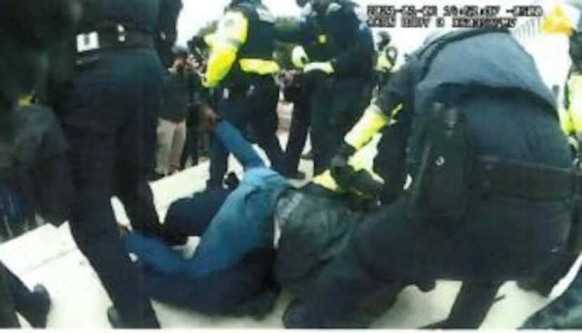 Robert Wayne Dennis is shown on top of a police officer after taking him to the ground.