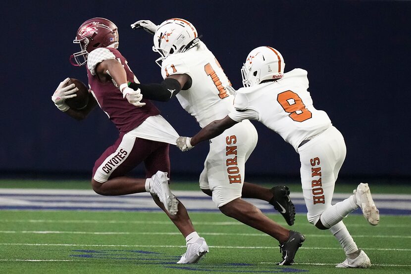 Frisco Heritage wide receiver Tatum Bell (2) is pulled down by W.T. White defensive back...