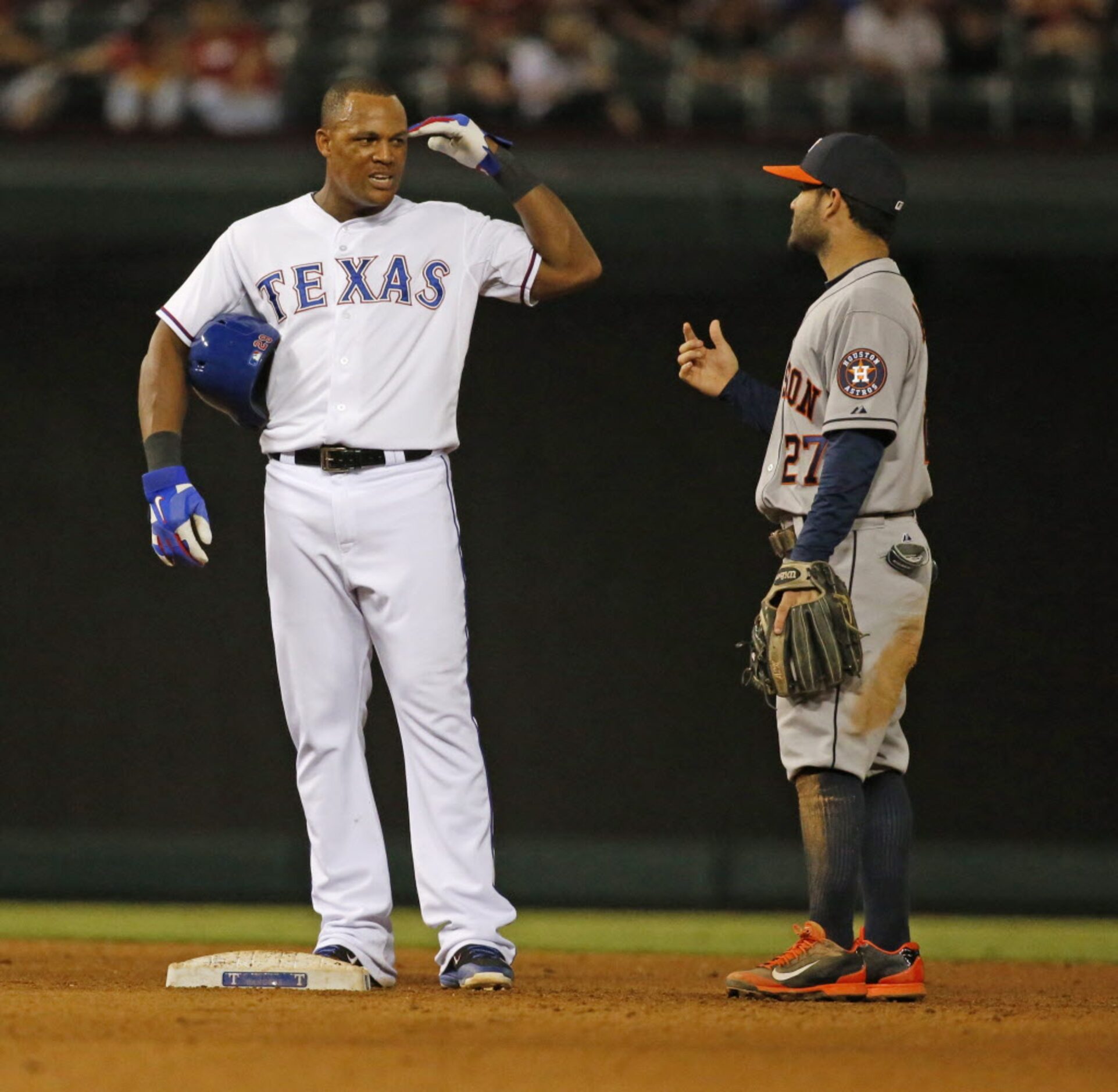 Texas' Adrian Beltre and Houston's Jose Altuve visit during a break in play in the seventh...