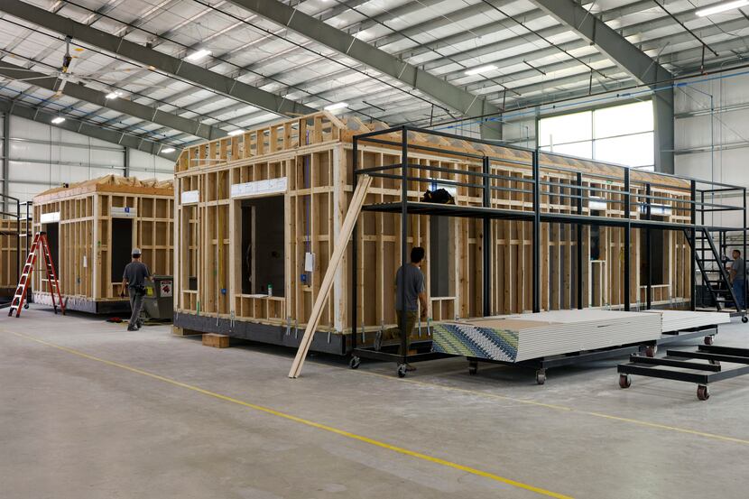 Crews work on modules of a home in HiFAB’s modular home factory in Grand Prairie.