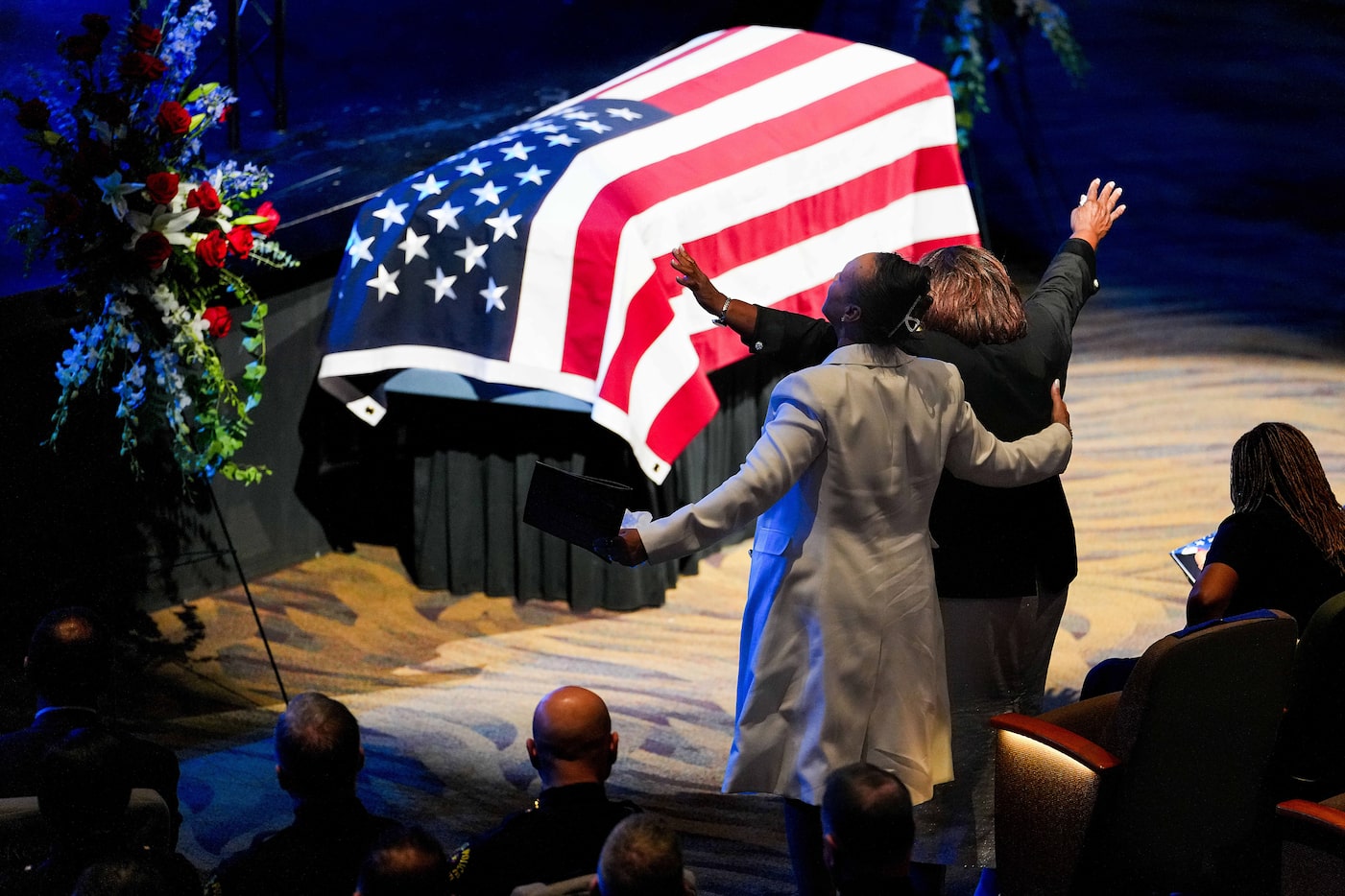 Cherie Jeffery (right) raises her arms in worship during funeral services for her son,...