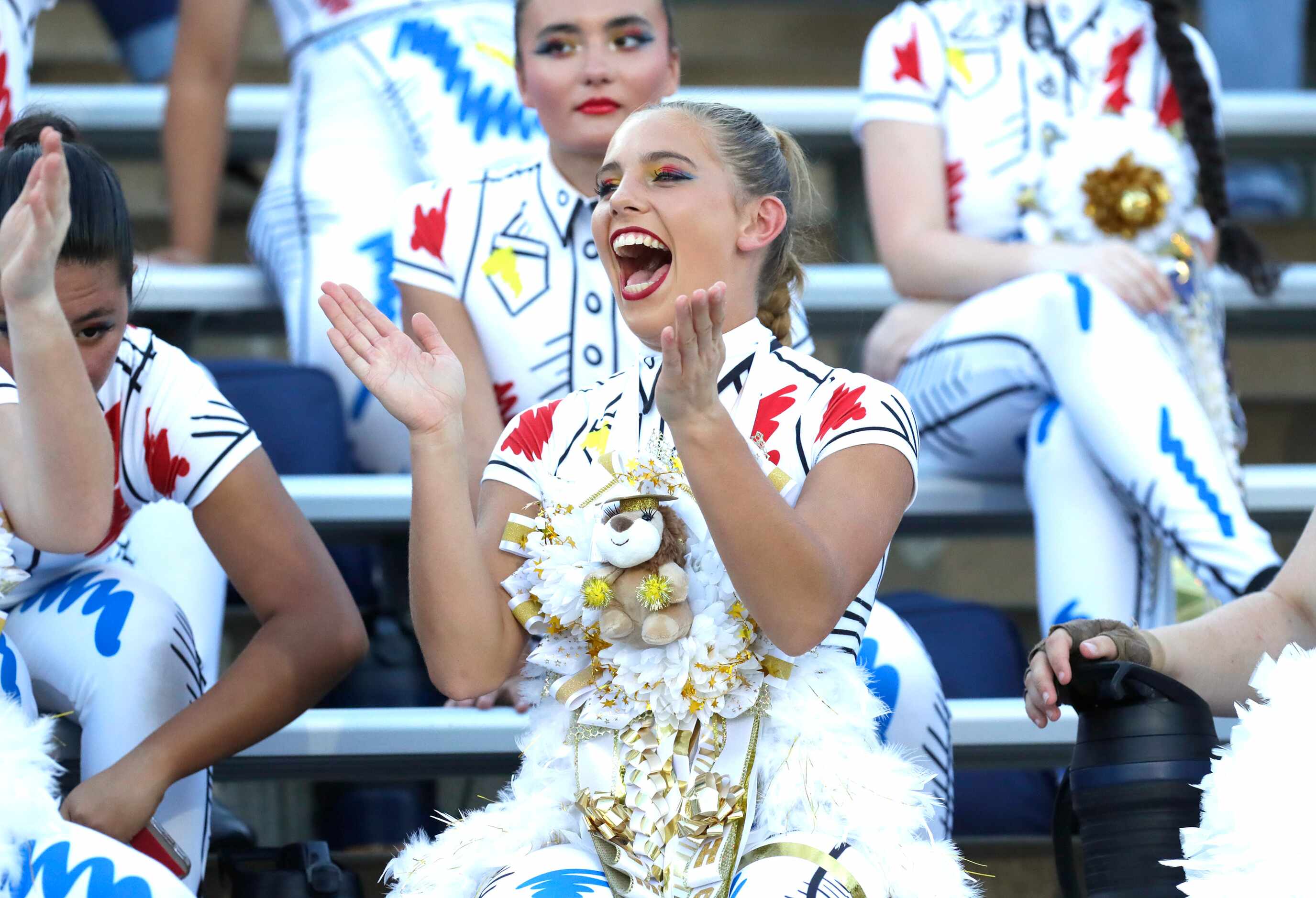 Emily Snidely, 17, with the McKinney High School Color Guard, cheers as McKinney High School...