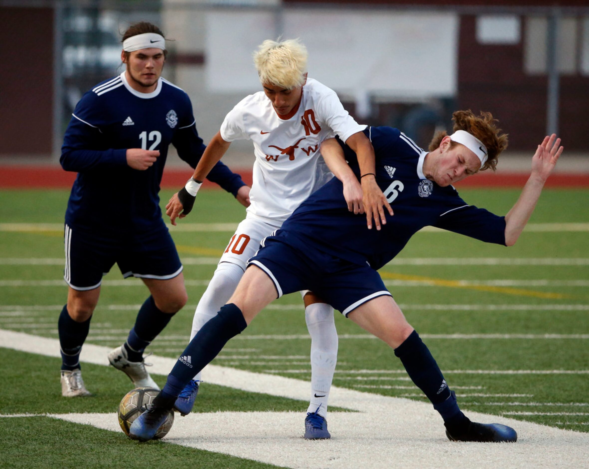 Flower Mound's Reese Mullins (12), left, and Peyton Weeter (6) battle W.T. White's Byron...