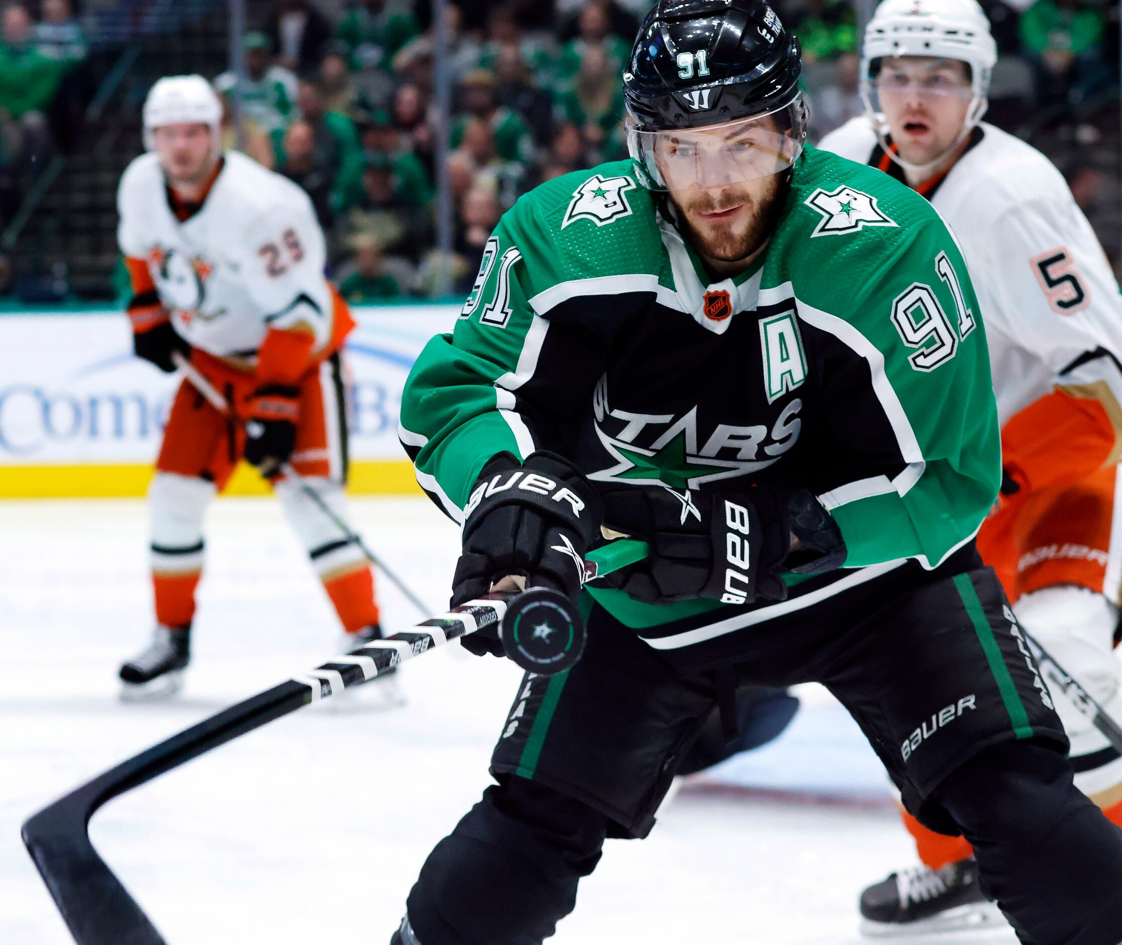 Dallas Stars center Tyler Seguin (91) tries to strike the puck with his stick as he battled...