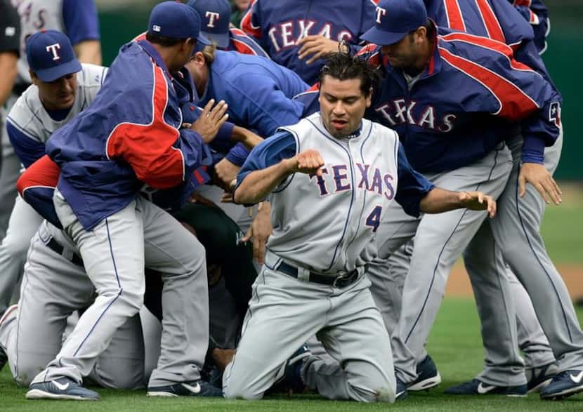 Texas Rangers pitcher Vicente Padilla emerges from a bench-clearing brawl after hitting...