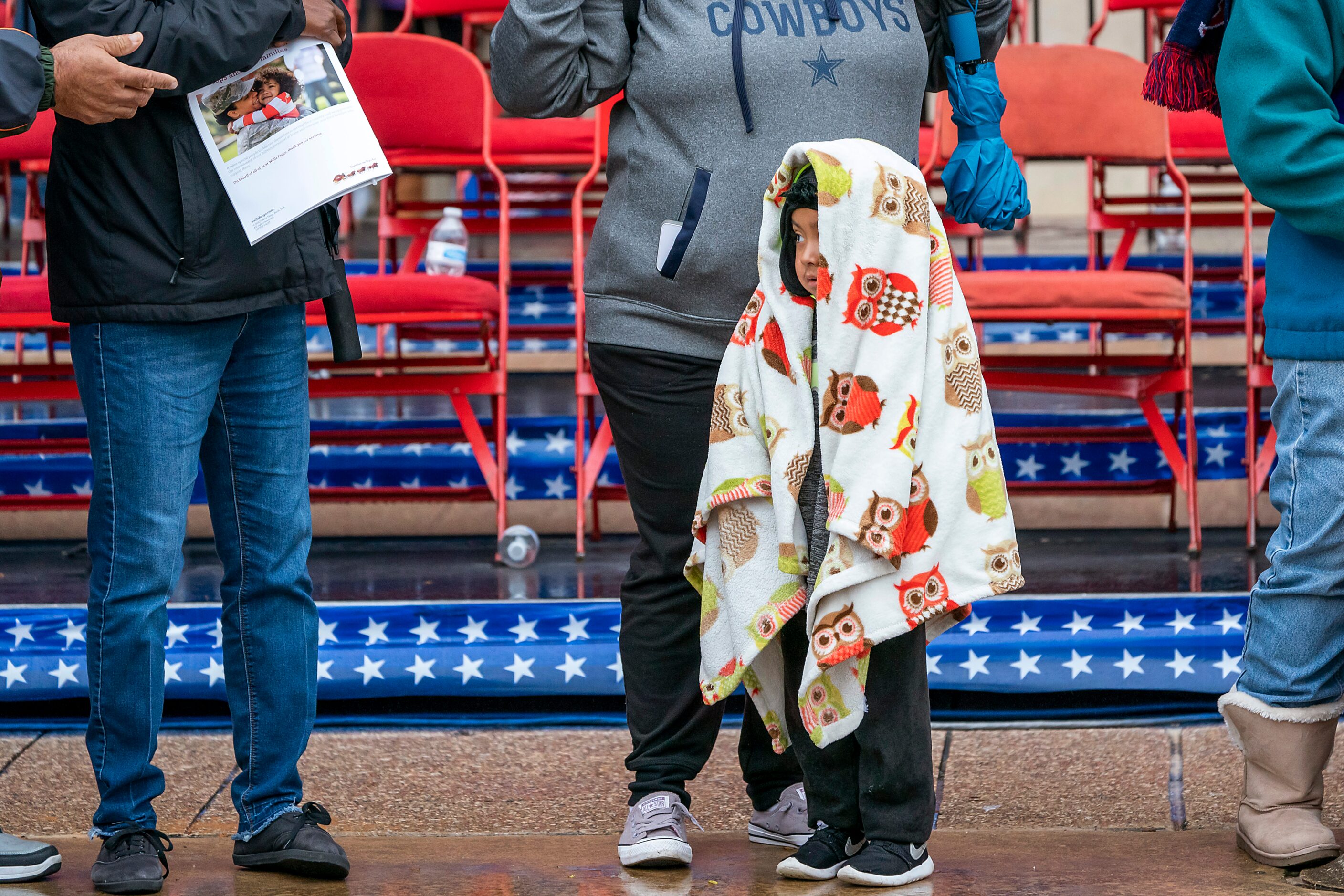 Uriel Martinez, 3, of Irving, huddles under a blanket during The Greater Dallas Veterans Day...