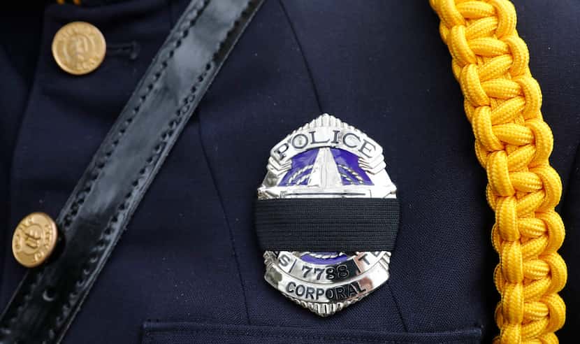 A black mourning band covers the badge of Dallas police office C. Anderson honoring...
