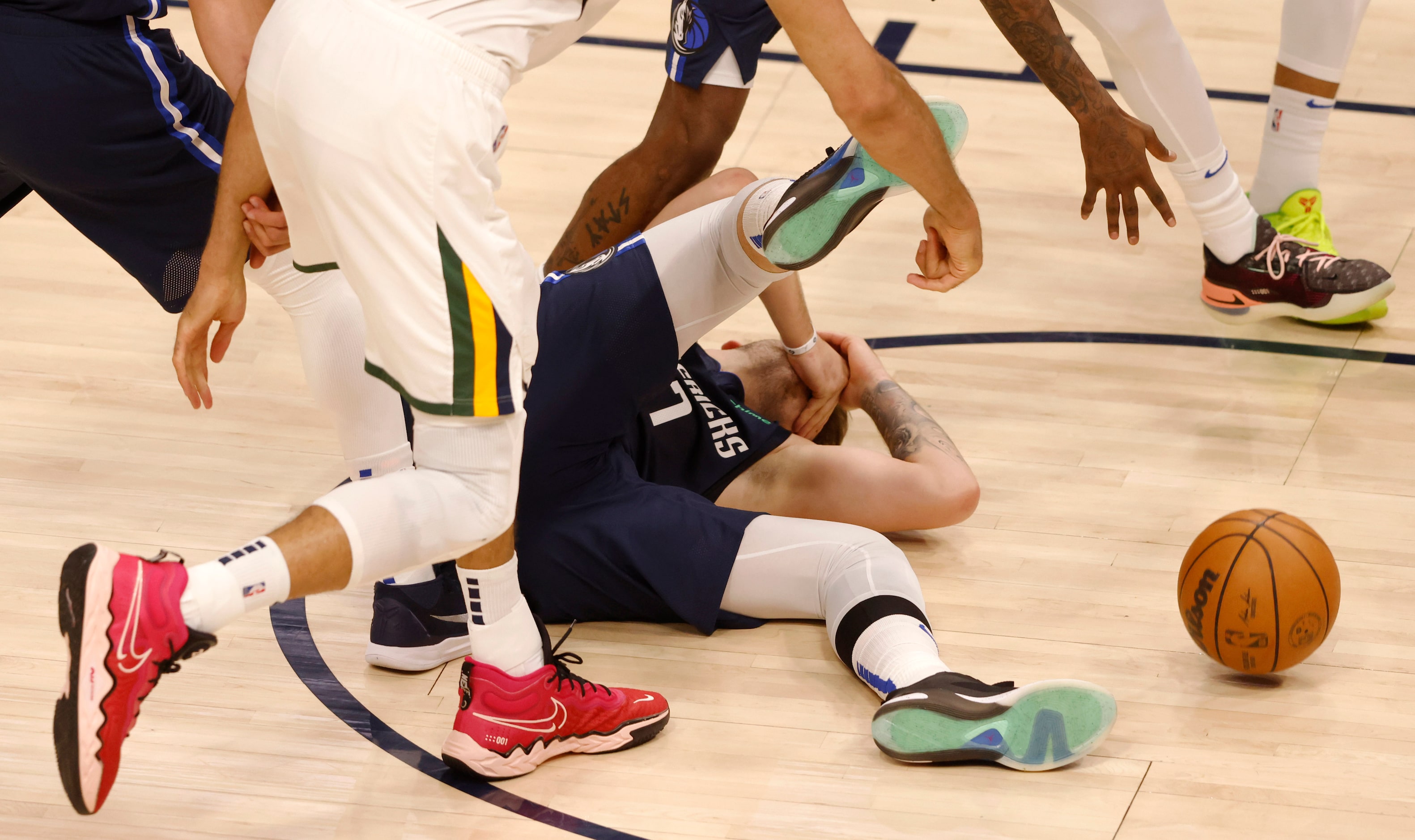 Dallas Mavericks guard Luka Doncic (77) falls after getting hit in the face by Utah Jazz...