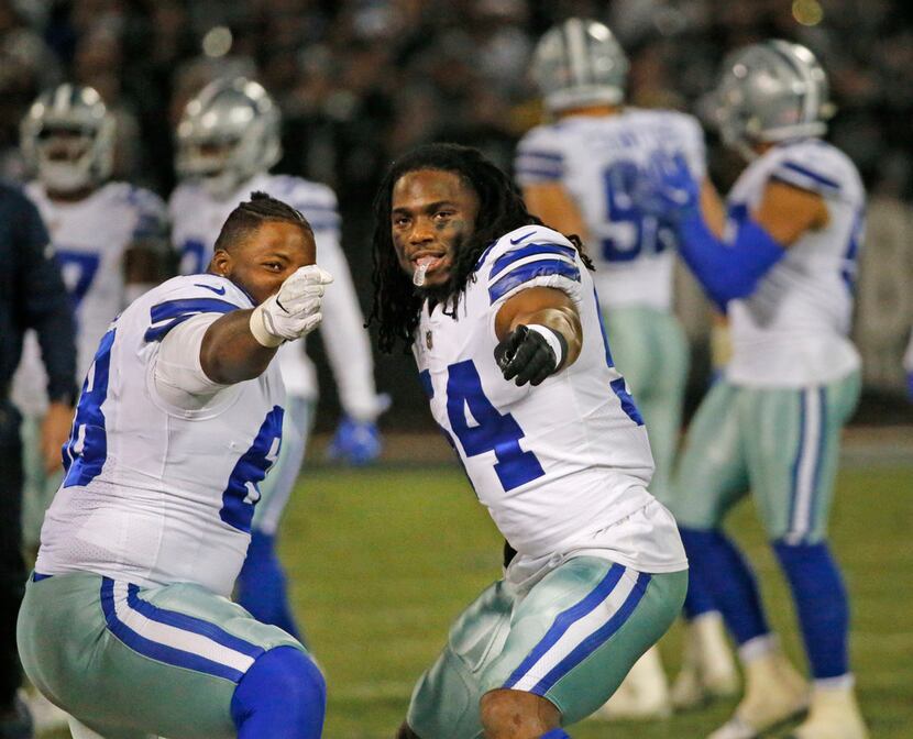 Dallas Cowboys defensive end Daniel Ross (68) and  linebacker Jaylon Smith (54) signal a...