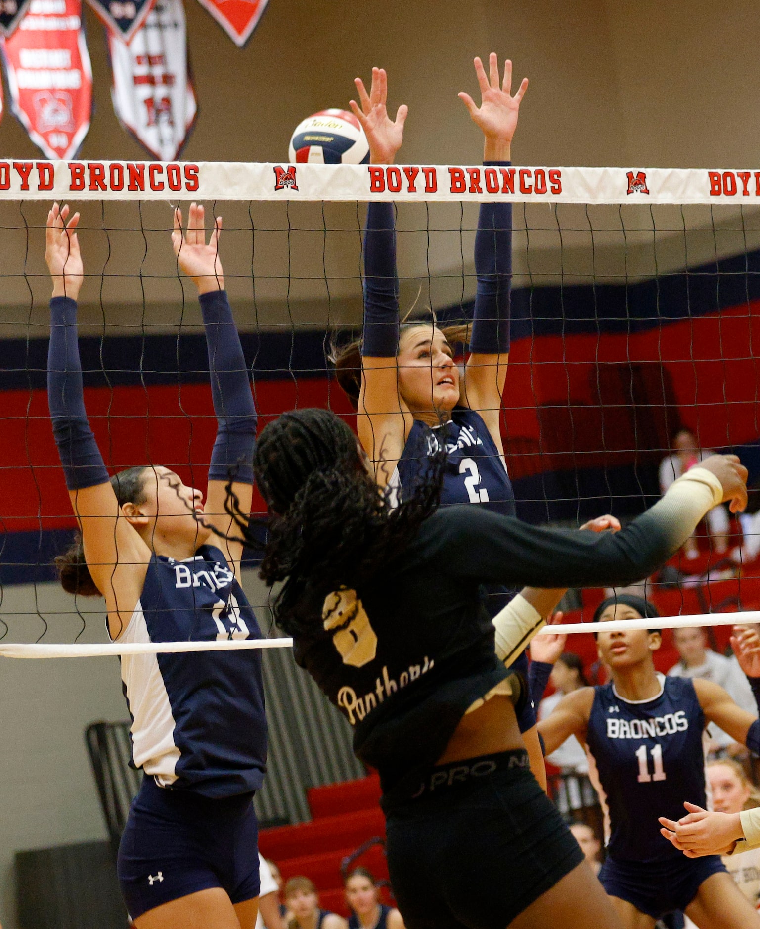 Plano East's Simone Heard (8) spikes the ball past McKinney Boyd's Kam Wood (13) and...