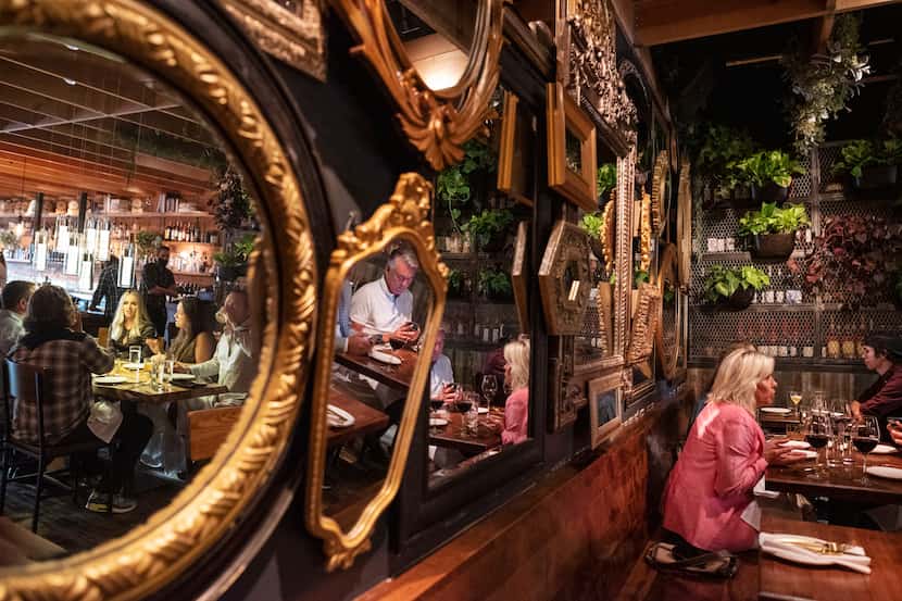 A wall covered in a variety of mirrors decorates the dinning area inside Rye Restaurant on...