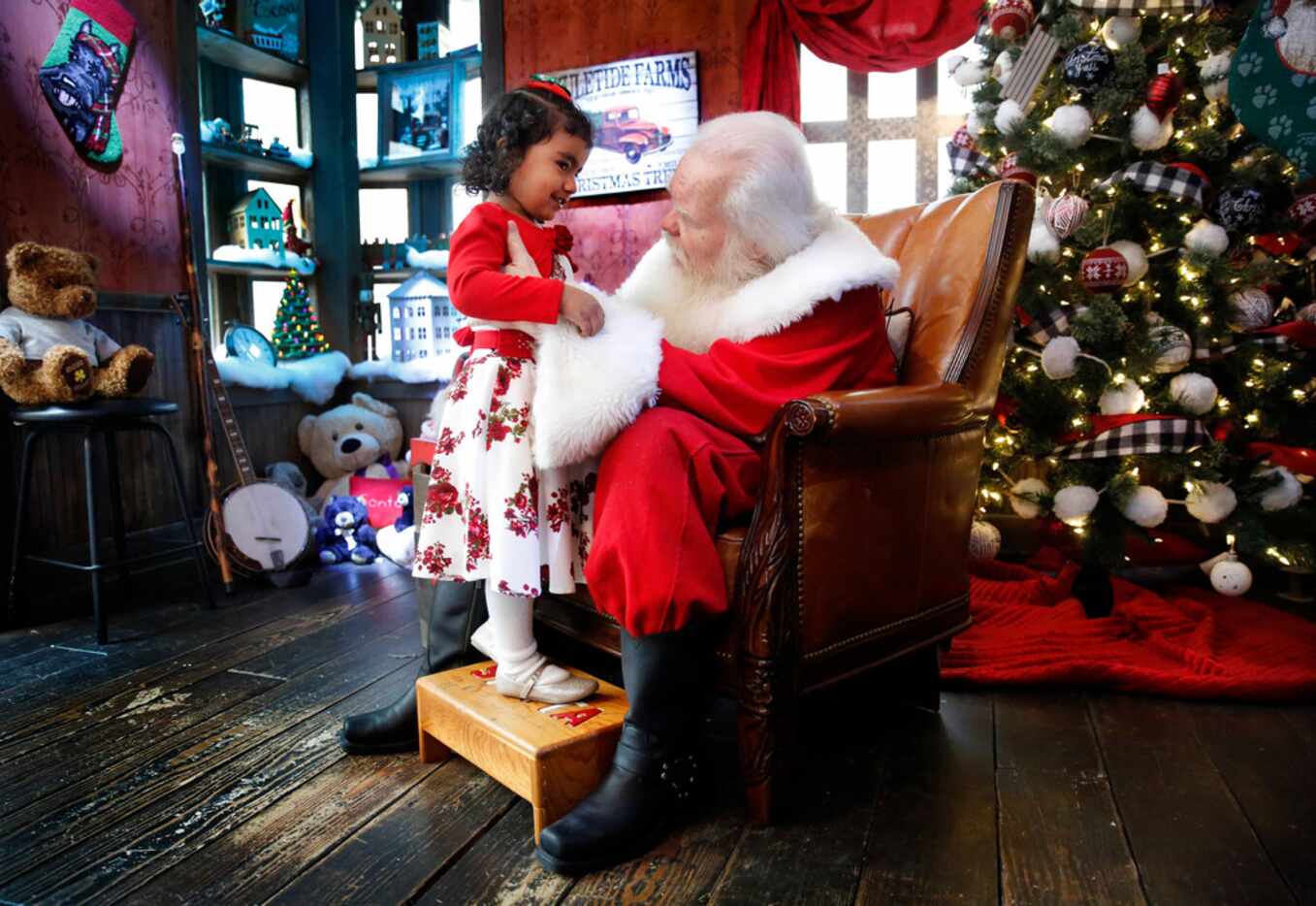Santa Claus listens to 3 year-old Abigail Campos of Richardson as she makes a visit to his...
