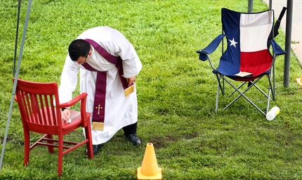 The Rev. Michael Picard, a Regnum Christi priest, disinfected a parishioner's chair after a...