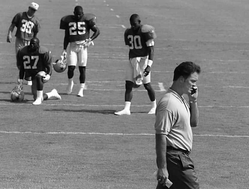Caption: 7-18-95..Stephen Jones talks on his phone  during a Dallas Cowboys workout at...