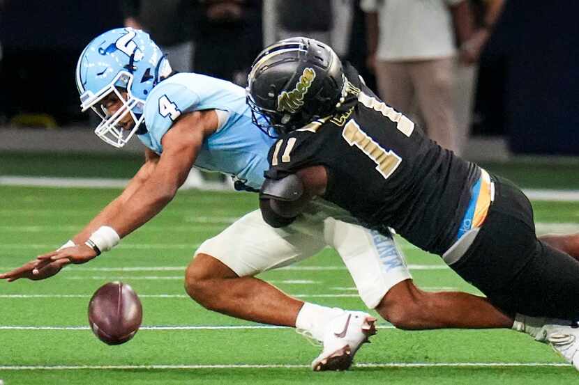 Frisco Emerson quarterback Michael Hawkins (4) fumbles as he is hit by South Oak Cliff...