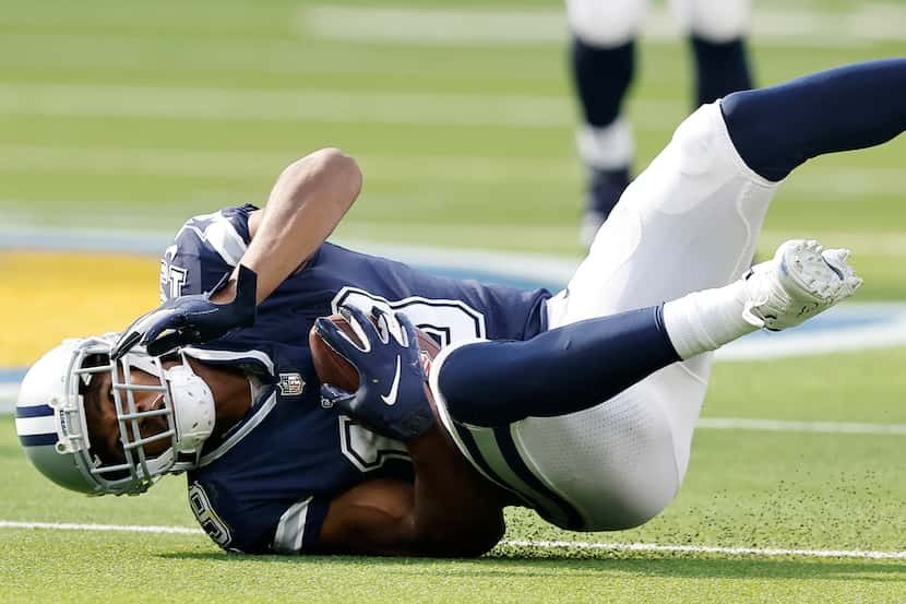 El receptor abierto de los Cowboys de Dallas, Amari Cooper, cae al suelo después de una...